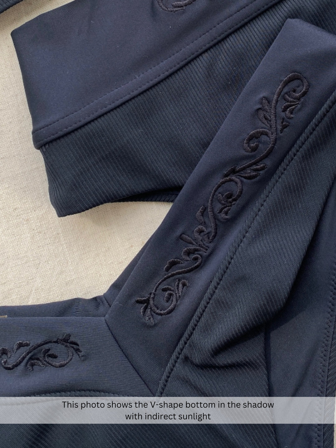 Bikini bottom V-shape in black, close up of embroidery and rib fabric